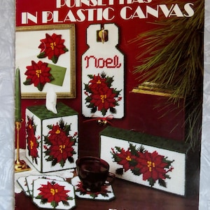 May include: A craft leaflet for making poinsettia decorations in plastic canvas. The leaflet includes instructions for making a tissue box cover, coasters, a door hanger, and a small framed picture. The leaflet is titled "Poinsettias in Plastic Canvas" and is by Joan E. Ray.