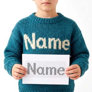 Könnte beinhalten: Türkisblauer Strickpullover mit dem Wort "Name" in cremefarbenen Buchstaben. Die Person hält ein Papier mit dem Wort "Name" in einem Kreuzstichmuster.