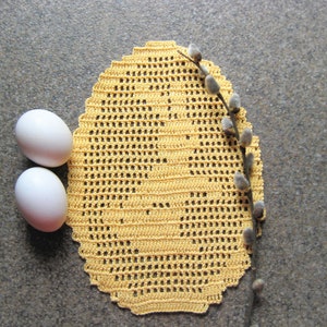 Peut inclure: Deux œufs blancs et une dentelle crochetée jaune avec une branche de saule.