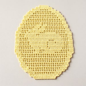 May include: A pale yellow oval-shaped crochet doily featuring an intricate openwork grid pattern. The textile piece has a scalloped edge and is crafted with fine yarn, displaying a consistent stitch structure throughout the entire decorative item.