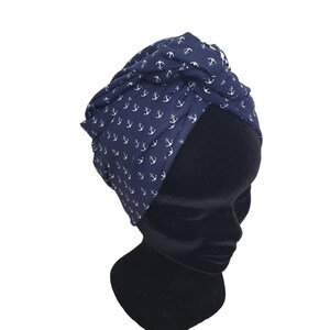 Puede incluir: Una diadema estilo turbante azul marino con un estampado de anclas blancas. La tela est&aacute; recogida y anudada en la parte superior, creando un accesorio elegante y c&oacute;modo. Esta diadema de tem&aacute;tica n&aacute;utica es perfecta para a&ntilde;adir un toque de estilo a cualquier atuendo.