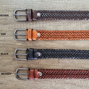 K&ouml;nnte beinhalten: Vier geflochtene Lederg&uuml;rtel in den Farben Braun, Beige, Schwarz und Cognac. Jeder G&uuml;rtel hat eine silberne Schnalle und einen kleinen Metallnieten.