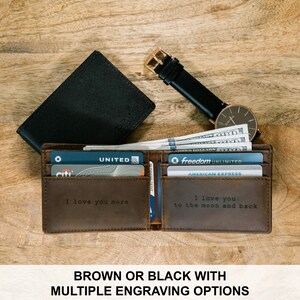 May include: Brown leather wallet with a personalized engraving that says "I love you more". The wallet is open and has credit cards and cash inside. The wallet is on a wooden surface.