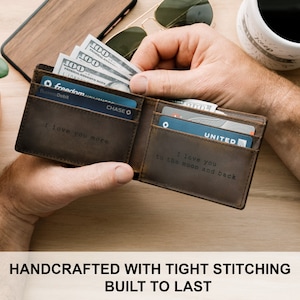 May include: A brown leather wallet with a personalized message that reads "I love you more" on the inside. The wallet is open and has cash and credit cards inside.
