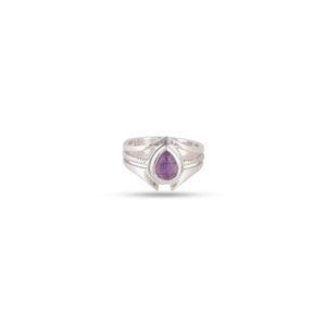 May include: A silver ring with a teardrop-shaped amethyst gemstone set in the centre.