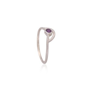 May include: A silver ring with a purple gemstone set in a delicate, open design.