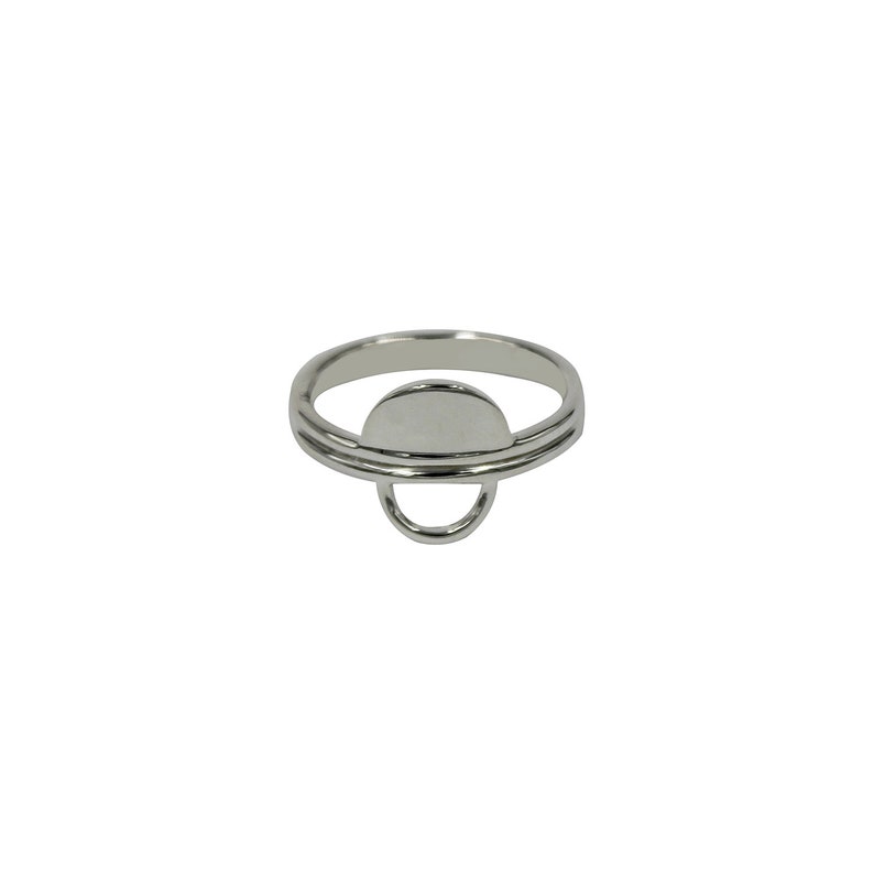 May include: A silver ring with a circular design. The ring has a double band and a small circle in the center.