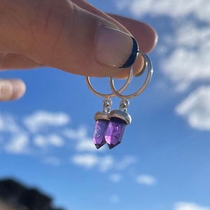 Puede incluir: Un par de pendientes de aro de plata con colgantes de cristal de amatista púrpura.