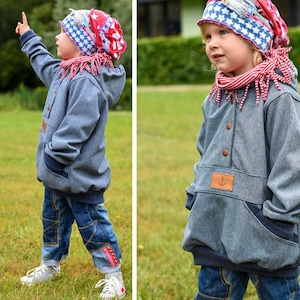 May include: Two children wearing blue denim jackets with red and white star patterned hats. The jackets have a brown patch with an anchor design on the front.