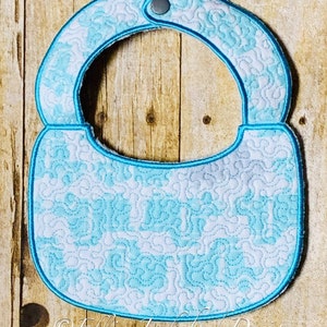 May include: A light blue baby bib with a white and blue swirl pattern. The bib has a snap closure at the neck.