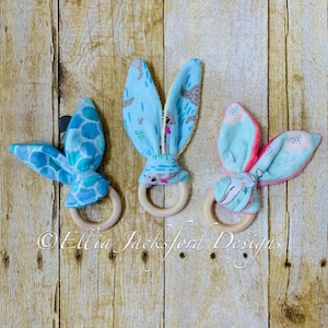 Puede incluir: Tres mordedores de madera con orejas de conejo de tela. Los mordedores están hechos de madera natural y tienen un acabado liso. Las orejas de conejo están hechas de tela suave y colorida con diferentes patrones. Los mordedores son una excelente manera para que los bebés exploren sus sentidos y desarrollen su motricidad fina.