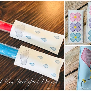 May include: Two white fabric pouches with embroidered designs. One pouch has a cloud and raindrops, the other has a kite. Two other pouches are white with embroidered flowers. One pouch is blue with a pink kite.