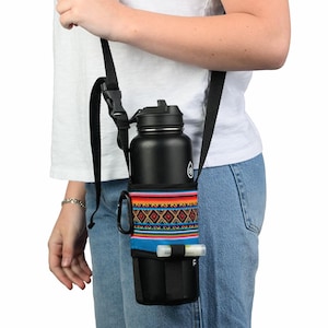 May include: Black insulated water bottle in a black carrier with a colorful woven design. The carrier has a black adjustable strap and a small pocket. A lip balm is in the pocket.