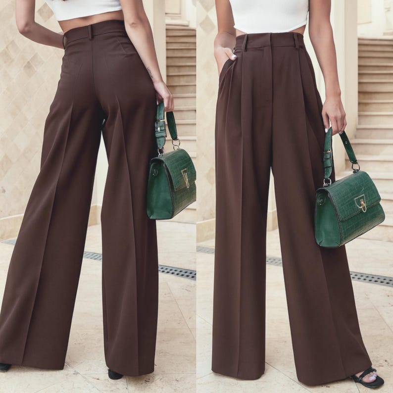 May include: Two views of brown wide-leg trousers with a high waist and belt loops. A green handbag with a gold-colored clasp and strap is held in each image. The trousers have pleats in the front.
