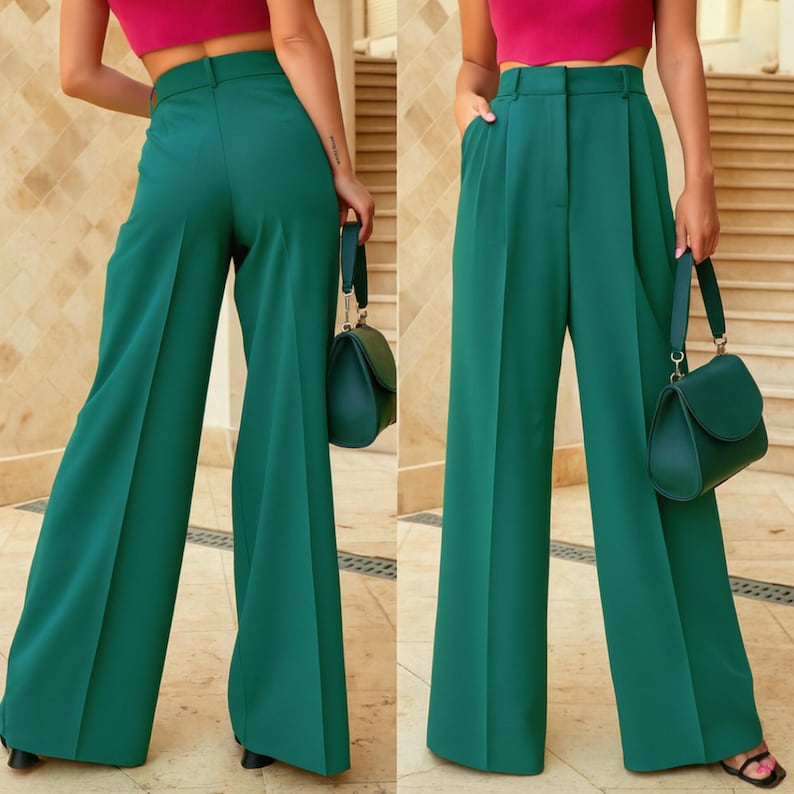 May include: Emerald green wide-leg trousers with a high waist and pleats. The trousers are paired with a matching green handbag. The model is wearing a pink crop top and black sandals. The trousers have a classic, tailored design.