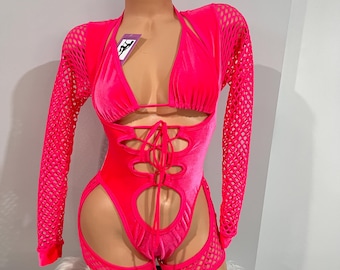 May include: A bright pink bodysuit with cut-out details and a matching fishnet top with long sleeves. The bodysuit has a lace-up front and cut-out sides. The outfit is displayed on a mannequin.