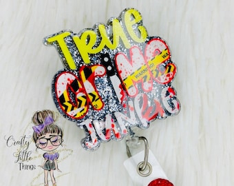 Può includere: Un porta badge in glitter argento con il testo "True Crime Junkie" in rosso e giallo. Il porta badge ha un strass rosso sul rotolo retrattile del badge.