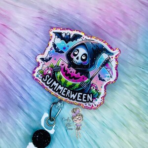 Peut inclure: Un porte-badge scintillant et coloré avec un Grim Reaper de dessin animé tenant une pastèque avec le texte "Summerween".