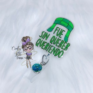 May include: A green and white glitter badge reel with the text "Fue sin querer queriendo" and a green and white hat design.
