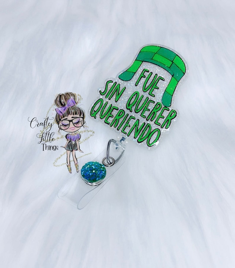 May include: A green and white glitter badge reel with the text "Fue sin querer queriendo" and a green and white hat design.