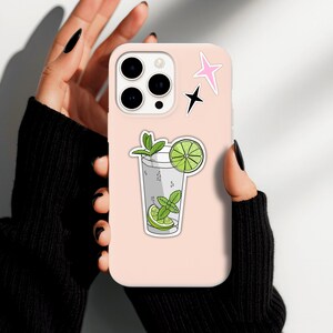 Tropical vacation vibes green mojito cocktail with lime and mint garnish die-cut vinyl sticker stuck to the back of a mobile phone.