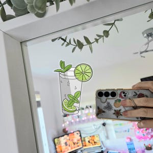 Tropical vacation vibes green mojito cocktail with lime and mint garnish die-cut vinyl sticker stuck to a mirror.