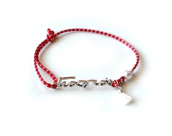 May include: Red and white string bracelet with a silver charm that says "Forever" and a white tassel.