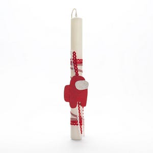 Puede incluir: Una vela de Pascua blanca decorada con cinta roja y blanca y un personaje de Among Us de fieltro rojo.