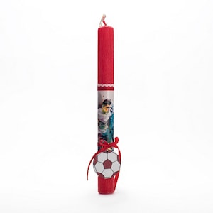 Puede incluir: Vela de Pascua roja con un diseño de jugador de fútbol y un amuleto de balón de fútbol blanco.
