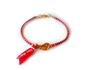 May include: Red and white braided bracelet with a gold wing charm and a red ribbon tag that says "Good Morning".