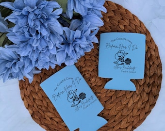 May include: Two light blue foam can coolers featuring black text and graphics. The design includes the words The Coastal Crew, Before Her I Do, Allie's Bachelorette, and Padre Island, accompanied by an illustration of a cowboy boot and a seashell.