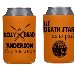 May include: Two orange can coolers with black text and graphics. The first cooler says "Kelly & Brad Anderson May 4th, 2024" with two crossed lightsabers. The second cooler says "til DEATH STAR do us part" with a black Death Star graphic.