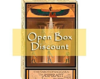 May include: A rectangular tarot card deck box featuring Egyptian-themed artwork with a winged figure, columns, and standing figures. The text reads The Tarot of Saqqara, The Aspirant, Sam, and The Utchat. A yellow banner overlays the centre.