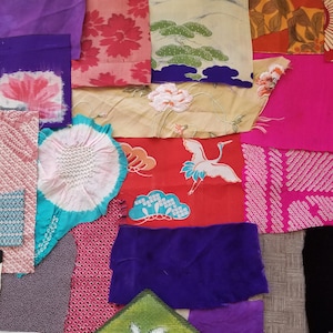 May include: A patchwork quilt made of various fabrics in different colors and patterns, including red, pink, purple, blue, green, and white. The fabrics are sewn together in a random pattern, creating a unique and colorful design.