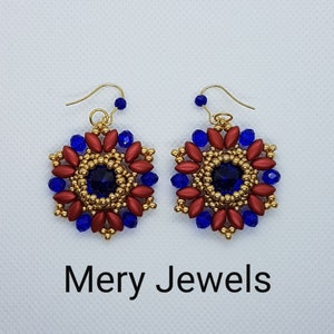 Può includere: Un paio di orecchini dorati con perline rosse e blu, con una pietra preziosa blu centrale. Gli orecchini hanno la forma di un fiore.