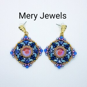 Könnte beinhalten: Ein Paar goldfarbene Ohrringe mit quadratischem Design, verziert mit blauen, rosa und goldenen Perlen. Die Ohrringe haben ein geometrisches Muster und eine rosa Mitte.