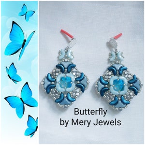 Può includere: Un paio di orecchini con perline blu e argento con un design a farfalla. Gli orecchini sono etichettati "Butterfly by Mery Jewels".