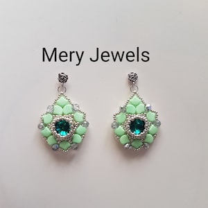 Puede incluir: Un par de pendientes de cuentas verde menta con una joya verde esmeralda en el centro. Los pendientes tienen un diseño floral y están adornados con cuentas plateadas y una pequeña parte superior en forma de rosa. El texto "Mery Jewels" está arriba.