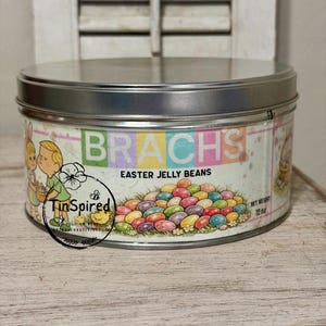 Puede incluir: Una lata redonda de metal de Brach's Easter Jelly Beans. La lata presenta una etiqueta colorida con el nombre de la marca, el nombre del producto y un gráfico de un montón de gominolas. Peso neto: 340 gramos.