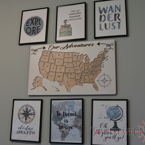 May include: A wall gallery featuring framed prints with travel-themed quotes and images, including a map of the United States, a compass, a globe, and the words "Wanderlust" and "Our Adventures".