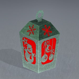 May include: A green paper lantern with a red snowman and snowflake designs. The lantern has a loop at the top for hanging.