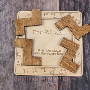 Może przedstawiać: Drewniana układanka Four-Z z czterema elementami w kształcie litery Z i kwadratową podstawą. Podstawa zawiera tekst "Four-Z Puzzle" i "Fit all four pieces into the square hole". Układanka wykonana jest z jasnobrązowego drewna.