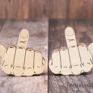 Op de afbeelding: Twee houten hand-uitsparingen met de middelvinger omhoog, een populair gebaar van uitdaging. De uitsparingen zijn gemaakt van lichtbruin hout en liggen op een houten oppervlak.