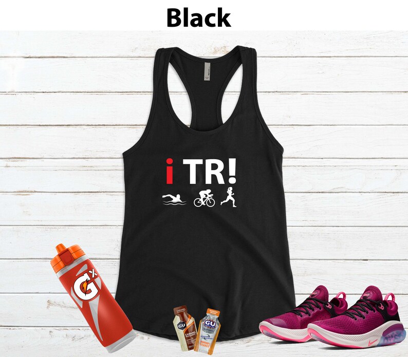 May include: Black racerback tank top with the text "i TR!" and triathlon icons. Includes a red Gatorade bottle, two GU energy gel packets, and a pair of pink running shoes.