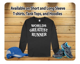 Puede incluir: Camiseta negra de manga larga con texto blanco que dice "Worlds Greatest Runner". La camiseta está disponible en manga corta y larga, camisetas sin mangas y sudaderas con capucha.