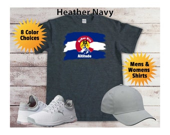 Puede incluir: Camiseta azul marino jaspeada con un gráfico de una bandera de Colorado con el texto "We Run With Altitude". La camiseta está disponible en 8 colores. Camisetas para hombres y mujeres.
