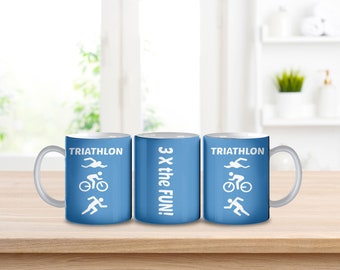 Puede incluir: Tres tazas de cerámica azules con texto blanco e iconos. Las tazas de la izquierda y la derecha dicen "TRIATHLON" con un icono de nadador, ciclista y corredor. La taza del medio dice "3 X the FUN!"