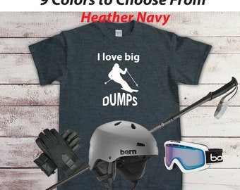 Puede incluir: Una camiseta azul marino jaspeada con el texto "I love big DUMPS" y una silueta blanca de un esquiador. La camiseta se muestra con un bastón de esquí, un casco de esquí gris, guantes de esquí negros y gafas de esquí blancas.
