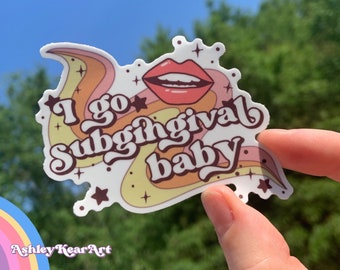 May include: A white sticker with a pink, orange, and yellow swirl design. The sticker features the text "I go subgingival baby" in a retro font. A red open mouth with white teeth is in the center of the sticker.