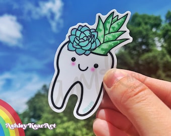 May include: A white tooth sticker with a happy face and a green succulent plant growing out of the top. The sticker is on a blue sky background.